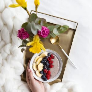 Ciotola con banana e frutti di bosco per una colazione sana