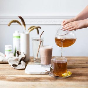 Colazione sana Herbalife Nutrition e una mano che versa una bevanda al tè