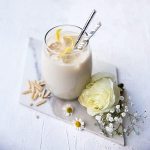 Bicchiere di frullato proteico vaniglia e mandorla su un tavolo di marmo